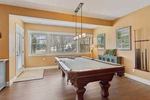 Recreation room featuring wood finished floors, baseboards, and pool table