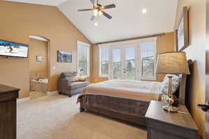 Bedroom featuring light carpet, vaulted ceiling, recessed lighting, ensuite bath, and french doors
