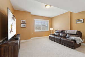 Carpeted living area with baseboards