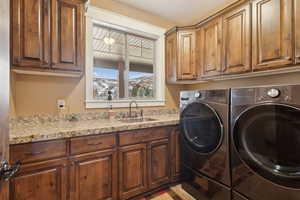 Clothes washing area featuring cabinet space and washer and dryer