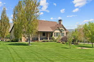 Back of property featuring a yard, a chimney, an outdoor fire pit, and stucco siding