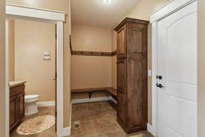 Bathroom featuring toilet, vanity, baseboards, and tile patterned floors