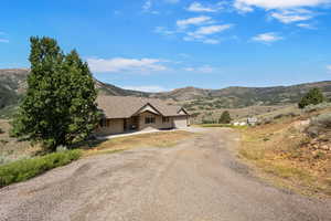 View of front of house with driveway, a garage, and a mountain view