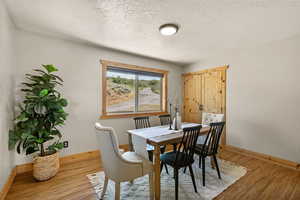 Dining space featuring light wood-type flooring and a textured ceiling