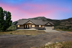 View of front of house with concrete driveway, an attached garage, covered porch, and a mountain view