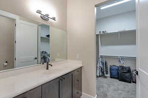 Bathroom with vanity and a walk in closet