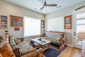 Living room featuring wood finished floors, a ceiling fan, baseboards, and recessed lighting
