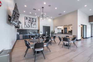 Dining space featuring a towering ceiling, recessed lighting, a chandelier, light tile patterned floors, and baseboards