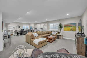 Living area with carpet floors, a desk, recessed lighting, healthy amount of natural light, and baseboards