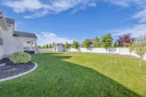 View of yard with a storage shed, an outbuilding, and a residential view