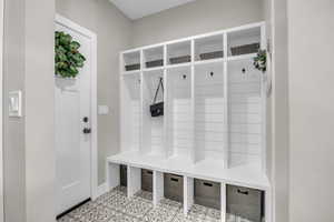 Mudroom featuring baseboards and light tile patterned floors