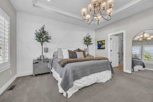 Bedroom with a chandelier, carpet, and baseboards