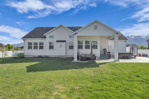 Back of house featuring a hot tub, an outdoor living space, a patio area, a mountain view, and stucco siding