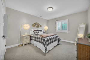Bedroom featuring light colored carpet and baseboards