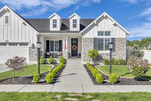 View of front of house with board and batten siding, stone siding, and a porch