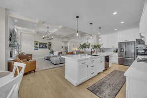 Kitchen with appliances with stainless steel finishes, open floor plan, a sink, recessed lighting, and light wood finished floors