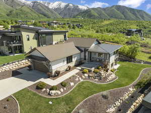 Aerial view of property and surrounding area featuring a mountainous background