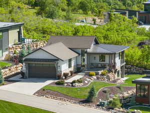 View of front facade featuring board and batten siding, an attached garage, concrete driveway, a standing seam roof, and metal roof