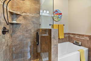 Full bath featuring a stall shower and a garden tub