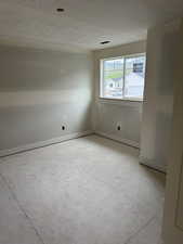 Unfurnished room with baseboards and a textured ceiling