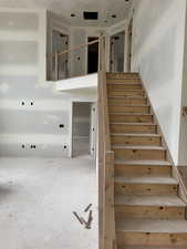 Stairway featuring a towering ceiling