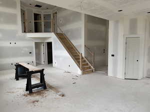 Unfurnished living room featuring stairway