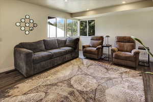 Living room with wood finished floors, baseboards, recessed lighting, and a textured ceiling