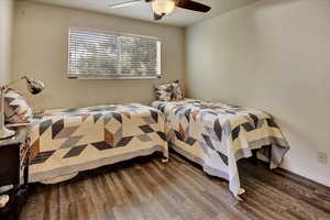 Bedroom with wood finished floors, ceiling fan, and baseboards