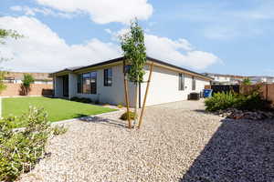 Rear view of house featuring stucco siding and central air condition unit