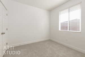 Spare room with light carpet and baseboards