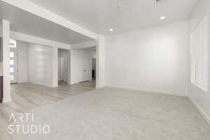 Spare room with light carpet, baseboards, and recessed lighting