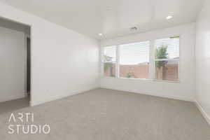 Spare room featuring light colored carpet, recessed lighting, and baseboards
