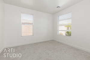 Empty room featuring carpet flooring and baseboards