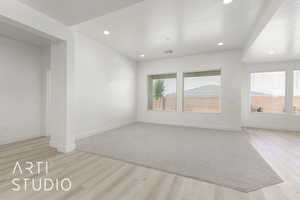 Unfurnished living room featuring light wood-type flooring, recessed lighting, and baseboards