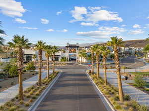 View of asphalt road featuring traffic signs, sidewalks, curbs, and a mountain view