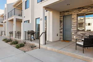 Entrance to property featuring stone siding and stucco siding