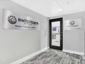 Doorway to outside with baseboards, carpet, and recessed lighting