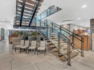 Stairs featuring a towering ceiling and concrete flooring