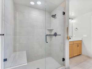 Full bathroom featuring a stall shower, tile patterned flooring, vanity, and baseboards