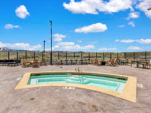 View of swimming pool with a mountain view, a patio, a hot tub, and fence
