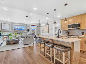 Kitchen featuring stainless steel microwave, light brown cabinets, a sink, light wood-style floors, and light countertops