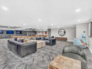 Carpeted living area with recessed lighting and baseboards