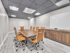 Office area with a drop ceiling and baseboards