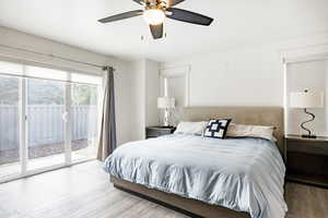 Bedroom with access to outside, wood finished floors, and a ceiling fan