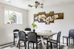 Dining room with baseboards, a chandelier, wood finished floors, and recessed lighting