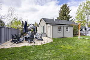 View of yard featuring a patio, a fire pit, and an outbuilding