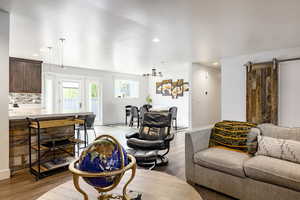 Living area featuring light wood-type flooring, recessed lighting, baseboards, and a barn door