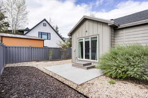 Rear view of property featuring a fenced backyard, a patio, a standing seam roof, metal roof, and board and batten siding