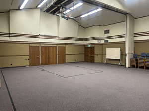 Carpeted recreational space with retractable basketball hoop in the ceiling.