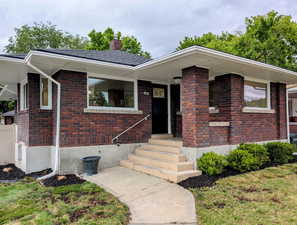 View of front of home with a chimney and brick siding